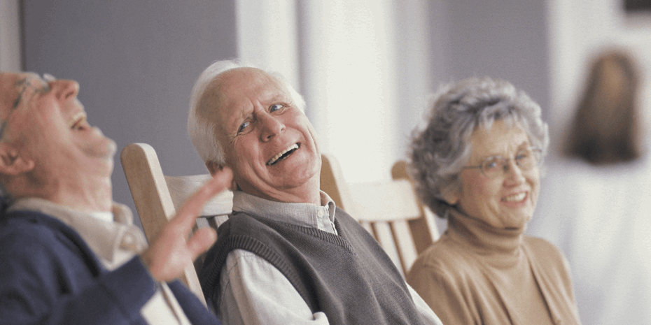Two elderly men and on elderly lady laughing